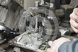 A mechanic assembles the manual transmission of a front-wheel drive car