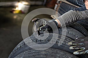 Mechanic assessing tire with calipers