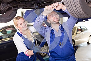 Mechanic and assistant working at auto repair shop