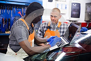 Mechanic and assistant working at service