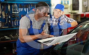 Mechanic and assistant working at service