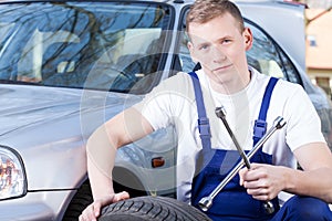 Mechanic with car wheel unscrewing key