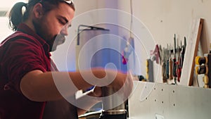 Mechanic in carpentry shop changing rotor part on spindle moulder