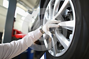 Mechanic changes car wheel in auto repair shop