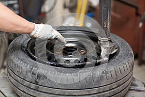 Mechanic changing car tire fitting. Wheel tyre repairing.