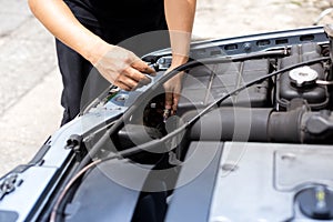 Mechanic changing headlight bulb in a car