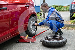 Mechanic Changing Tire With Wrench