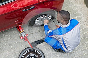 Mechanic Changing Tire With Wrench