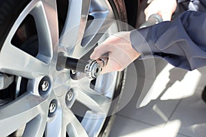 Mechanic changing wheel on car