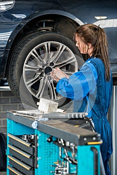 Mechanic Changing Wheel On Car At Garage