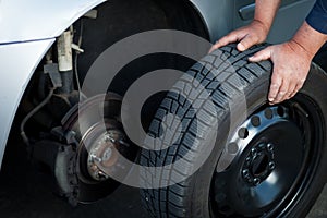 Mechanic changing a wheel of a modern car