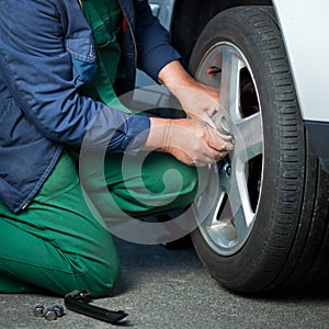 Mechanic changing a wheel of a modern car