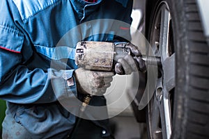 Mechanic changing a wheel of a modern car