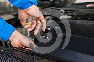 Mechanic checking car's oil level in a car service garage