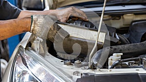 Mechanic is checking and change an air filter. Car mechanic working maintenance checking air filter in repair garage.
