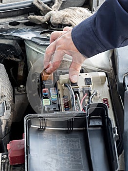 A mechanic checking the fuse box that controls the car`s electrical system