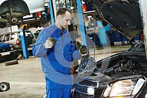 Mechanic checking oil level in automobile