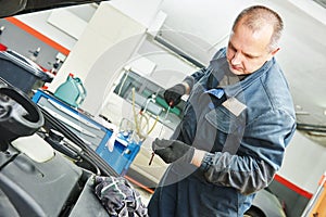 Mechanic checking oil level in automobile