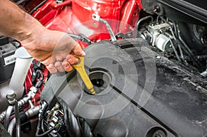 Mechanic checking the oil level in a car engine