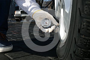 Mechanic checking tire air pressure at car service