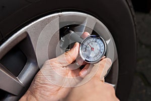 Mechanic checking tire pressure using gauge
