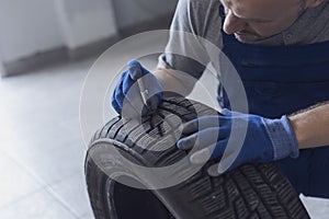 Mechanic checking tire tread depth and wear