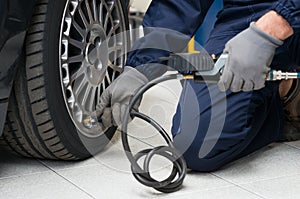 Mechanic Checking Tyre Pressure With Gauge