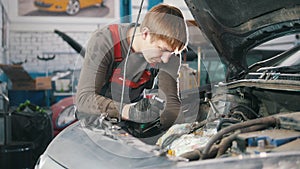 Mechanic checks and repairs automotive engine, car repair, working in the workshop, overhaul