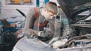 Mechanic checks and repairs automotive engine, car repair, working in the workshop, overhaul, under the hood