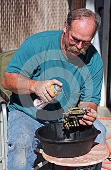 Mechanic cleans carburetor photo