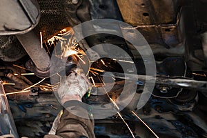 Mechanic cleans silencer pipe by angle grinder