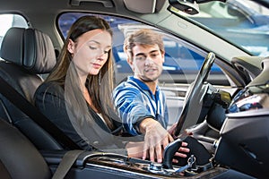 Mechanic demonstrating a second hand car to a potential customer