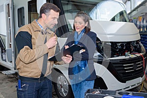 Mechanic discussing motorhome repairs with woman