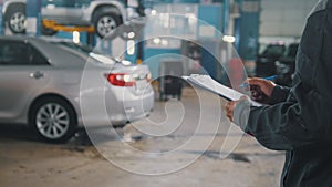 Mechanic doing checking of a car in a garage workshop