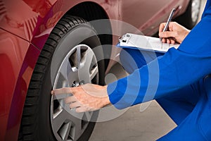 Mechanic Examining Car Wheel