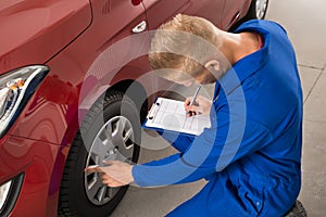 Mechanic Examining Car Wheel