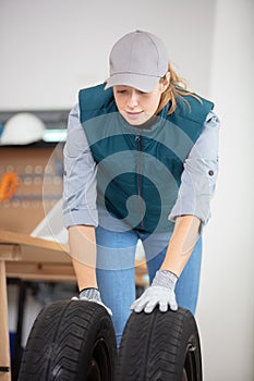 mechanic female pushing car tyres