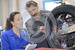 mechanic and female trainee working with tyre