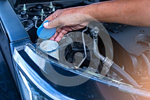 Mechanic fill fresh water into windscreen or in water tank wiper on car engine room