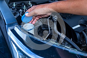 Mechanic fill fresh water into windscreen or in water tank wiper on car engine room