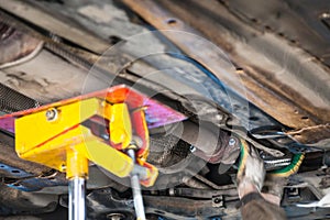 Mechanic fixes silencer pipe on car