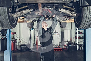 Mechanic Fixing Car on a Lift