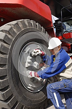 Mechanic fixing giant truck tire