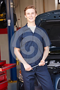 Mechanic in front of car at work