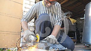 Mechanic grinding metal using circular saw. Worker cutting detail in garage or workshop. Man sawing iron part. Repairman