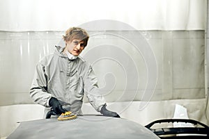 Mechanic grinds car part for painting. Car body work auto repair paint after accident