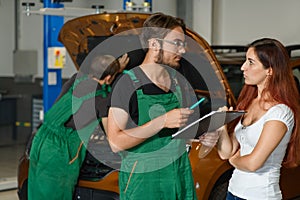A mechanic guy in a green suit tries to repair the engine of the