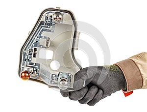 Mechanic hand in black protective glove and brown uniform holding used grey plastic light bulbs holder of car rear light isolated