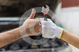 Mechanic hand checking and fixing a broken car in garage.hand o