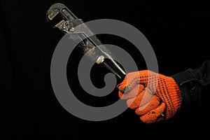 Mechanic hand hold pipe wrench on black background